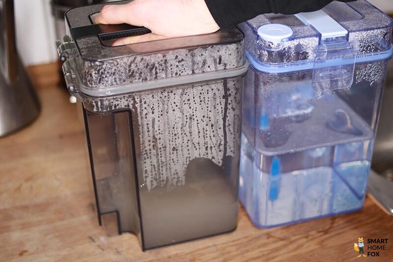 Der Schmutzwassertank der Ecovacs Deebot X1 OMNI Reinigungsstation ist samt Inhalt in der Nahaufnahme zu sehen